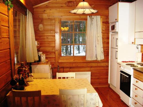 cocina con mesa y ventana en una cabaña en Коттедж на берегу живописного озера, en Kerimäki