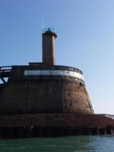 a lighthouse sitting on top of the water at LE WELCOME vue port appartement plain pied in Fécamp
