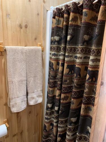 a bathroom with a shower curtain and a towel at Bearlodge Mountain Resort in Sundance