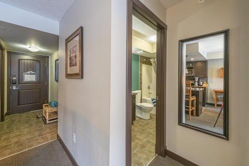 a hallway with a bathroom and a toilet and a mirror at Copperstone Resort - Mountain View 2 Bedroom Condo in Canmore