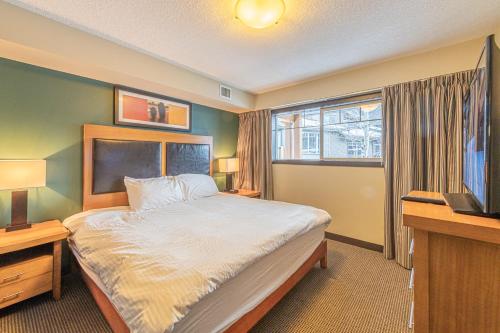 sypialnia z dużym łóżkiem i telewizorem w obiekcie Copperstone Resort - Mountain View 2 Bedroom Condo w mieście Canmore