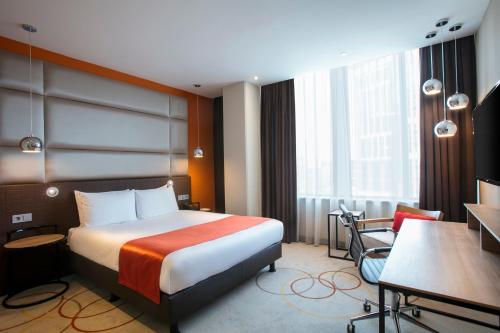 a hotel room with a bed and a desk at Holiday Inn Amsterdam - Arena Towers by IHG in Amsterdam