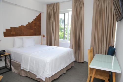 a bedroom with a white bed and a window at Kaleo Hotel Boutique in San Salvador