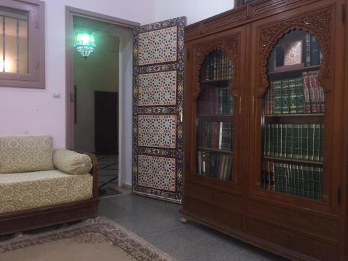 - un salon avec un canapé et une étagère à livres dans l'établissement Villa Tazi, à Meknès