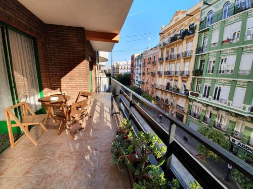 a balcony with a table and chairs and buildings at Apartamento Ruzafa in Valencia