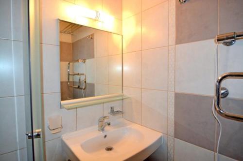 W łazience znajduje się umywalka i lustro. w obiekcie Sparta Apartments Kosmonaudi w mieście Narwa