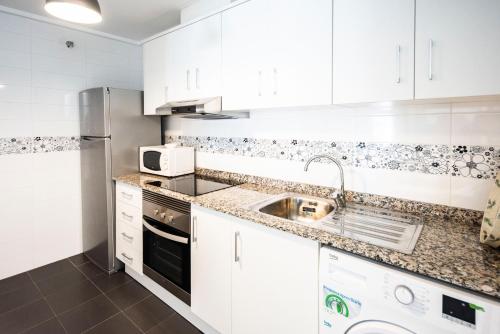 a kitchen with white cabinets and a sink at GLP ALTEA DREAMS in Altea