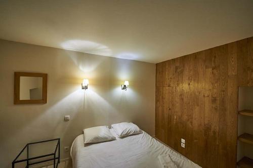 CorseulにあるGîte Le Logis - Manoir le Plessix Madeucのベッドルーム1室(ベッド1台、壁に照明2つ付)