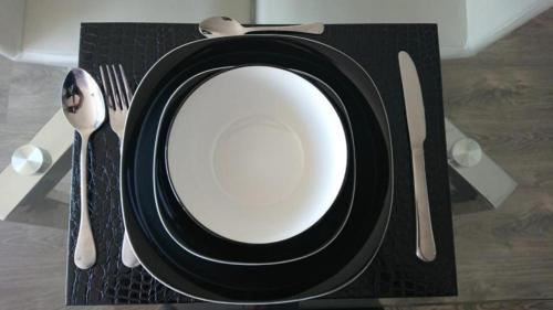 a black and white plate on a table with utensils at Apartamento Park Way Bogotá in Bogotá