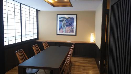 a dining room with a black table and chairs at Mutsumikan in Gero