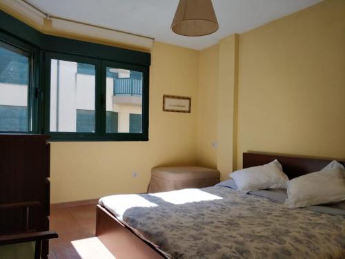 a bedroom with a bed and a window at Apartamento Playa Catedrales in Barreiros