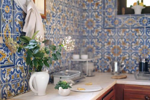 a kitchen with a vase with flowers on a counter at AmendoeirasHouse-SustainableLiving in Abrantes