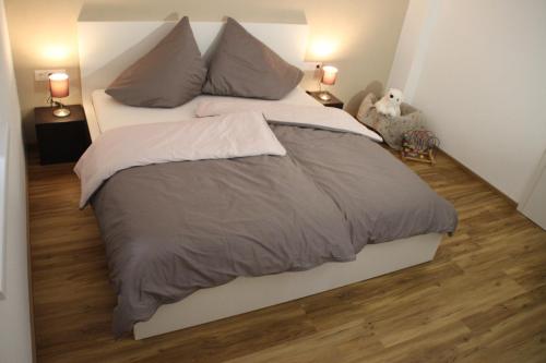 a large bed in a bedroom with wood floors at Landhaus Klara in Neustift im Stubaital