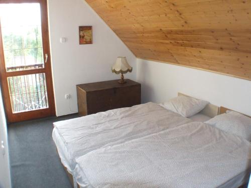 フォニョードにあるBoby nyaralóの白いベッドと木製の天井が備わるベッドルーム1室が備わります。