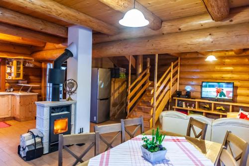 a dining room with a wood stove in a cabin at Chata Alexandra in Bobrovník