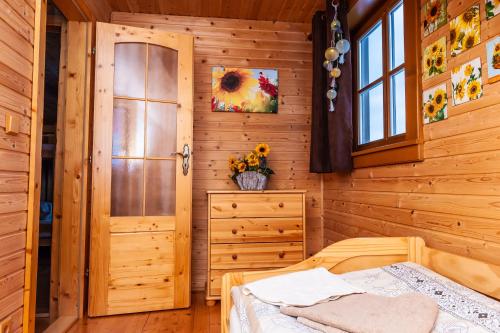 a bedroom with a bed in a wooden cabin at Chata Alexandra in Bobrovník