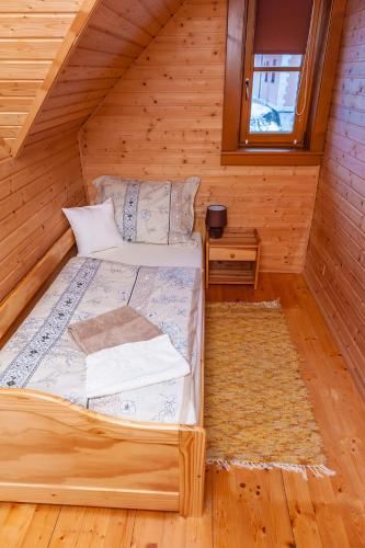 a bedroom with a bed in a wooden house at Chata Alexandra in Bobrovník