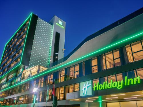 a building with a holiday inn sign in front of it at Holiday Inn Antalya - Lara by IHG in Antalya