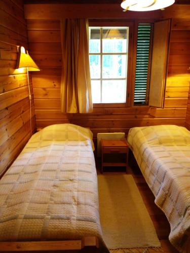 a bedroom with two beds and a window at Коттедж на берегу живописного озера in Kerimäki