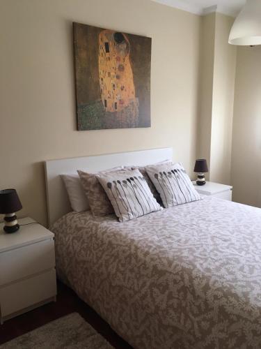 a bedroom with a bed with a painting on the wall at Oporto East House in Porto