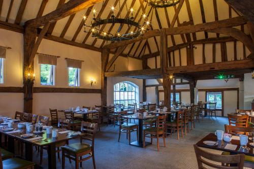 a dining room with tables and chairs and a chandelier at Holiday Inn Ashford Central by IHG in Ashford