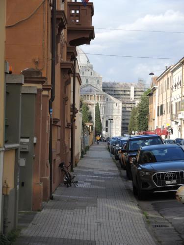 a street with cars parked on the side of a building at B&B Ariston Pisa Tower in Pisa