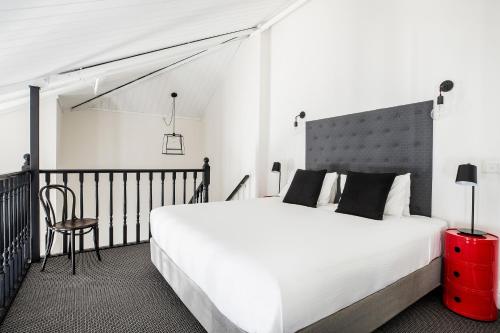 a bedroom with a large white bed and a chair at Quality Apartments Melbourne Central in Melbourne