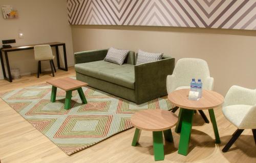 a living room with a couch and two tables and chairs at Suites Plaza Hotel & Wellness in Andorra la Vella