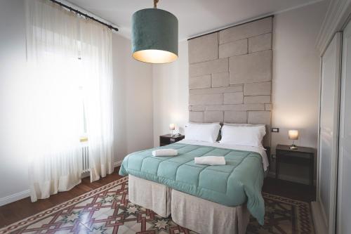 a bedroom with a bed and a large window at Piazza Duomo Deluxe in Cecina