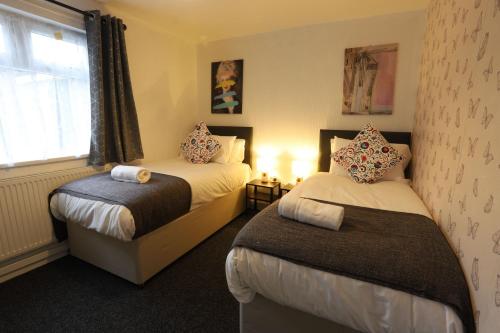 a hotel room with two beds and a window at B'ham NEC/Airport/HS2 Short Stay in Birmingham