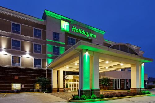 a hotel with a green sign on a building at Holiday Inn Hotels Batesville by IHG in Batesville