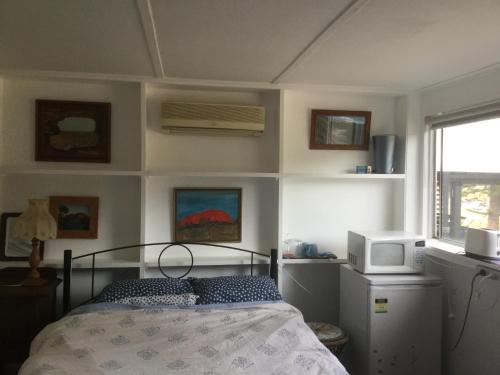 a bedroom with a bed and a microwave and a window at Character 1940s Property in Augusta