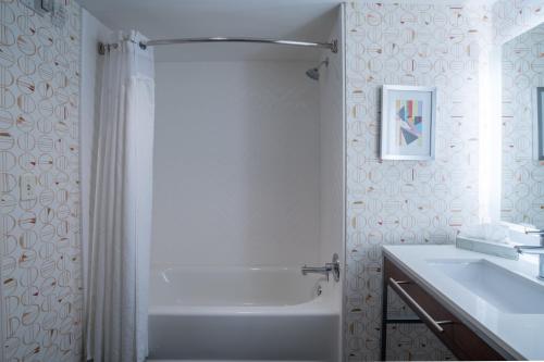 a white bathroom with a shower and a sink at Holiday Inn Atlanta/Roswell, an IHG Hotel in Roswell