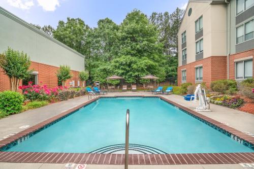 a swimming pool in a courtyard with a building at Holiday Inn Atlanta/Roswell by IHG in Roswell