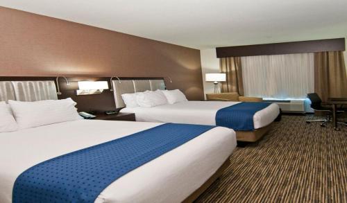 a hotel room with two beds and a desk at Holiday Inn Austin Airport by IHG in Austin