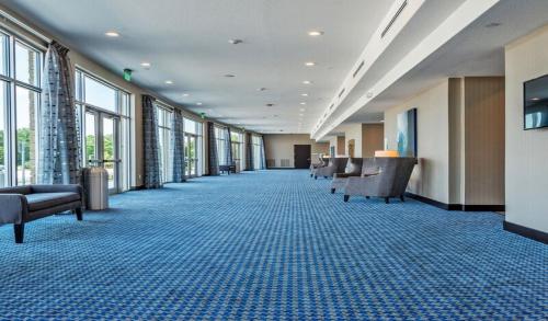 a long hallway with chairs and windows in a building at Holiday Inn Austin Airport by IHG in Austin