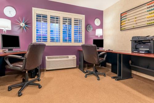 a room with two desks with chairs and a computer at Holiday Inn Auburn by IHG in Auburn