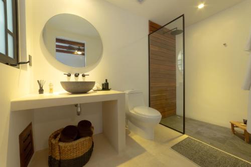 图卢姆BT Rooms Tulum的浴室里有洗手池、马桶和镜子。