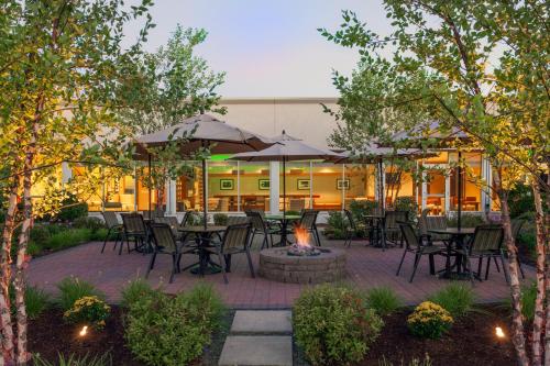 a patio with tables and chairs and a fire pit at Holiday Inn Bangor, an IHG Hotel in Bangor