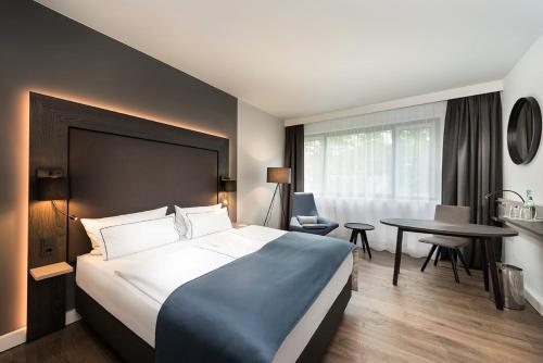 a hotel room with a large bed and a table at Holiday Inn Berlin City-West by IHG in Berlin