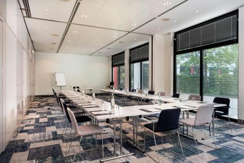 a conference room with tables and chairs and windows at Holiday Inn Berlin City-West by IHG in Berlin