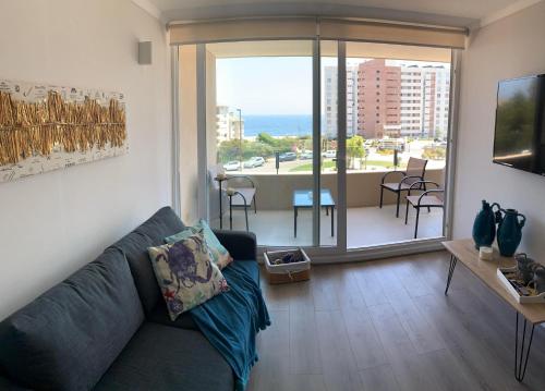 a living room with a couch and a view of the ocean at Departamento Familiar con Terraza Panorámica y a Pasos de la Playa en Punta Puyai in Papudo
