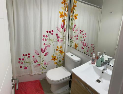 ein Badezimmer mit einem WC und einem Duschvorhang mit Blumen in der Unterkunft Departamento con terraza propia incluida en azotea en Punta Puyai in Papudo