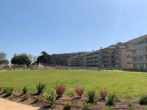 a large grassy field in front of a building at Departamento Familiar con Terraza Panorámica y a Pasos de la Playa en Punta Puyai in Papudo