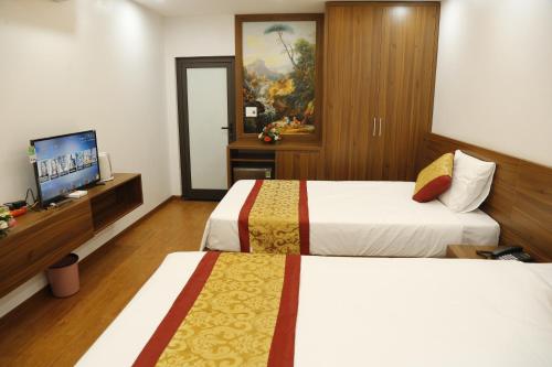 a hotel room with two beds and a television at Bảo Ngọc Diamond Hotel in Cao Bằng