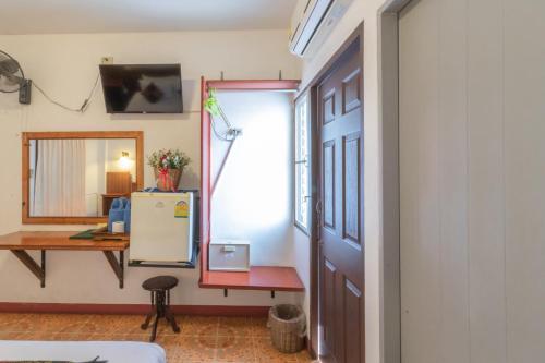 a room with a door and a table and a refrigerator at Rendezvous Oldtown Chiangmai in Chiang Mai