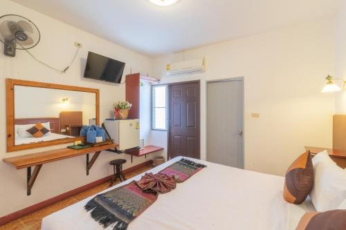a bedroom with a bed and a mirror at Rendezvous Oldtown Chiangmai in Chiang Mai