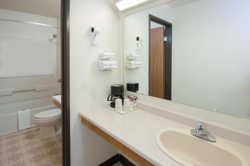 a bathroom with a sink and a toilet and a mirror at Super 8 by Wyndham Salmon Arm in Salmon Arm