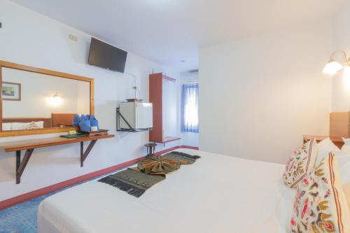 a hotel room with a bed and a mirror at Rendezvous Oldtown Chiangmai in Chiang Mai