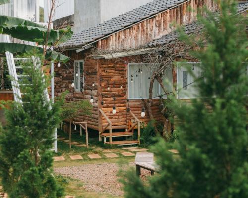 a log cabin with a bench in front of it at The November - Moc Chau in Mộc Châu